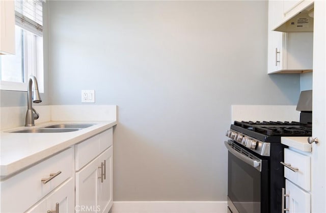 280 W S St, Rialto, CA 92376 - kitchen with stainless steel gas range oven, under cabinet range hood, white cabinetry, and light countertops
