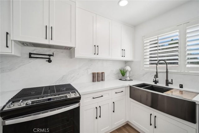 19040 Celtic St, Porter Ranch, CA 91326 - kitchen with gas stove, white cabinetry, premium range hood, tasteful backsplash, and recessed lighting