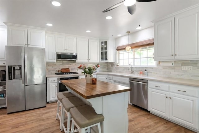330 Spruce St, Riverside, CA 92507 - kitchen with stainless steel appliances, wooden counters, white cabinetry, and recessed lighting