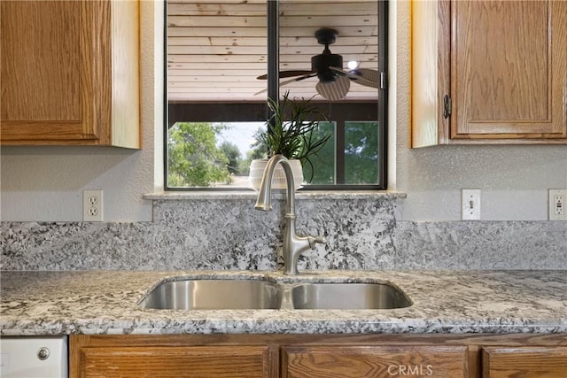 8140 Sherwood Blvd, Los Molinos, CA 96055 - kitchen featuring decorative backsplash, ceiling fan, light stone countertops, a textured wall, and brown cabinetry