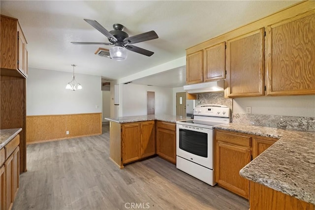 8140 Sherwood Blvd, Los Molinos, CA 96055 - kitchen with white range with electric cooktop, under cabinet range hood, a peninsula, ceiling fan, and a wainscoted wall