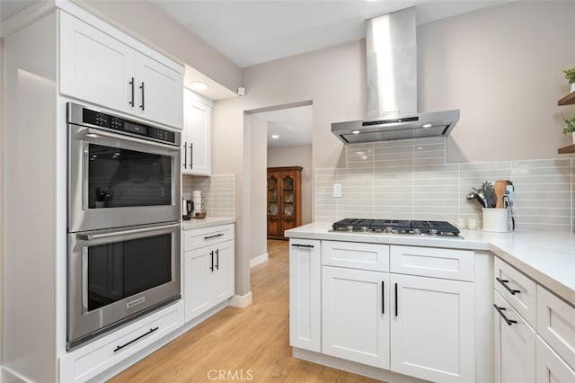 6207 Capistrano Ave, Woodland Hills, CA 91367 - kitchen with stainless steel appliances, wall chimney range hood, backsplash, white cabinetry, and recessed lighting