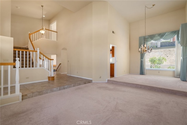 15280 Dunes Way, Moreno Valley, CA 92555 - unfurnished living room with a towering ceiling, carpet, arched walkways, stairs, and a chandelier