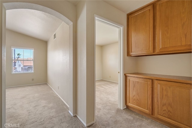 15280 Dunes Way, Moreno Valley, CA 92555 - corridor featuring light colored carpet, vaulted ceiling, and arched walkways