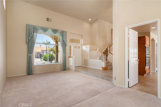 15280 Dunes Way, Moreno Valley, CA 92555 - entrance foyer featuring light colored carpet, stairway, arched walkways, and recessed lighting