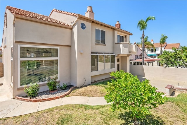 15280 Dunes Way, Moreno Valley, CA 92555 - rear view of house featuring a chimney, stucco siding, and a tiled roof