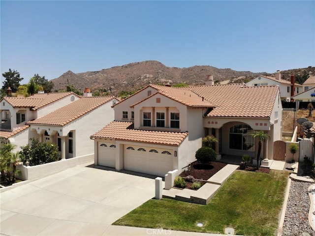 15280 Dunes Way, Moreno Valley, CA 92555 - mediterranean / spanish home with stucco siding, driveway, a tile roof, a mountain view, and a garage