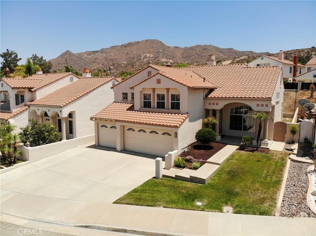 15280 Dunes Way, Moreno Valley, CA 92555 - mediterranean / spanish house with stucco siding, a tiled roof, concrete driveway, a mountain view, and an attached garage