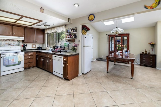 3329 Mandy Ln, Spring Valley, CA 91977 - kitchen with white appliances, under cabinet range hood, a skylight, light tile patterned floors, and vaulted ceiling