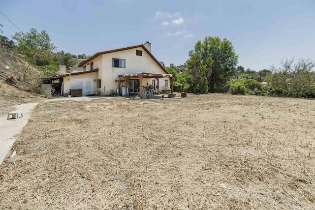 3329 Mandy Ln, Spring Valley, CA 91977 - back of property with a chimney, stucco siding, a patio, and a pergola
