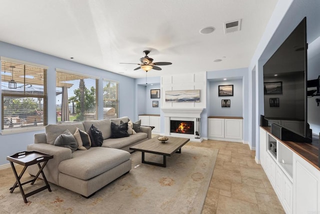 11550 Carowind Ln, Scripps Miramar, CA 92131 - living area with stone tile flooring, ceiling fan, and a lit fireplace