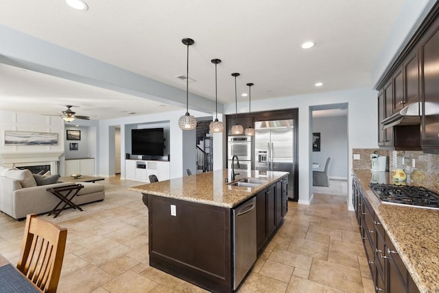 11550 Carowind Ln, Scripps Miramar, CA 92131 - kitchen featuring stainless steel appliances, ceiling fan, dark brown cabinets, decorative light fixtures, and tasteful backsplash