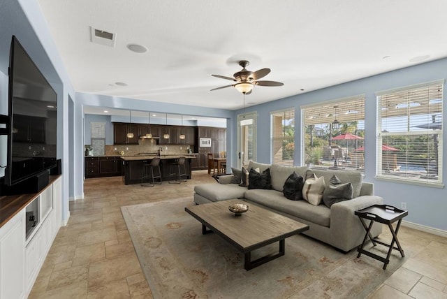 11550 Carowind Ln, Scripps Miramar, CA 92131 - living room featuring ceiling fan and light stone finish flooring