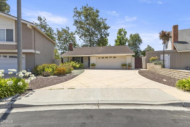 552 Cayo Grande Ct, Newbury Park, CA 91320 - view of front facade featuring a garage, stucco siding, driveway, and a chimney