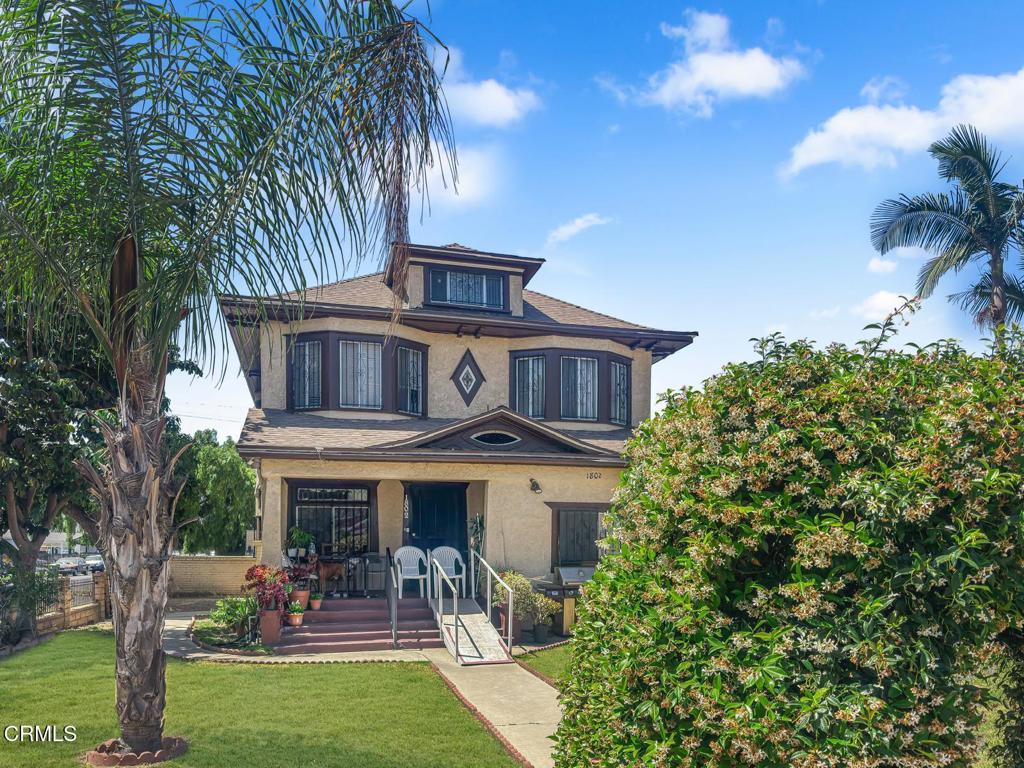 1802 W 49th St, Los Angeles, CA 90062 - view of front facade with stucco siding, a front yard, a porch, and roof with shingles
