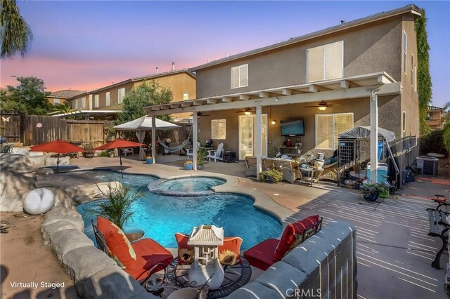2168 Stonewood St, Mentone, CA 92359 - pool at dusk featuring ceiling fan, a patio, and a pool with connected hot tub