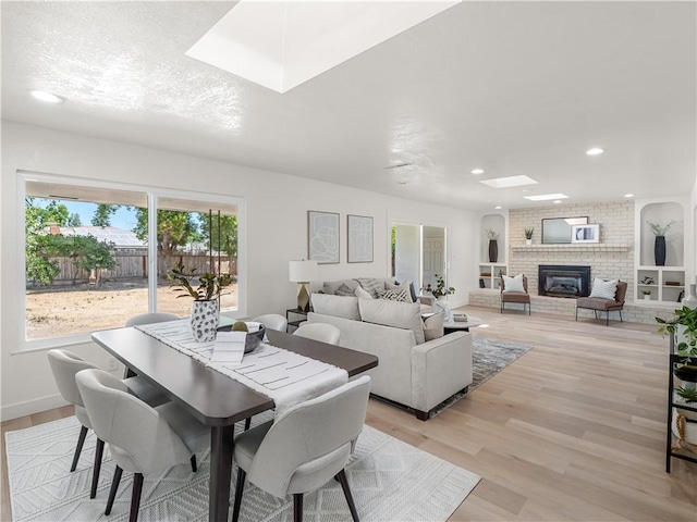 3236 W Browning Ave, Fresno, CA 93711 - dining area with a skylight, light wood-style flooring, a fireplace, and recessed lighting