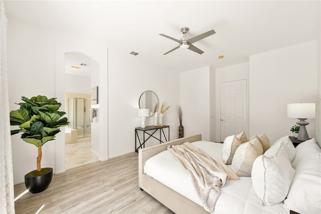 40065 Temple Ct, Murrieta, CA 92563 - bedroom with arched walkways, light wood-type flooring, connected bathroom, and ceiling fan