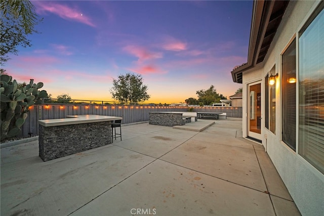 40065 Temple Ct, Murrieta, CA 92563 - patio terrace at dusk featuring a patio, a fire pit, and a water view