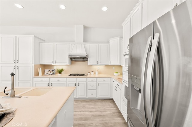 40065 Temple Ct, Murrieta, CA 92563 - kitchen with stainless steel fridge, gas stovetop, light countertops, white cabinets, and light wood-style floors