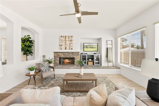40065 Temple Ct, Murrieta, CA 92563 - living area with ceiling fan, wood finished floors, a fireplace, and arched walkways