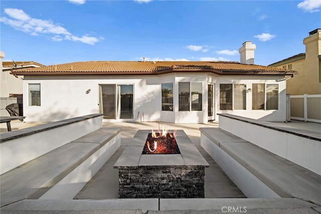 40065 Temple Ct, Murrieta, CA 92563 - back of property with a fire pit, a tile roof, a patio, stucco siding, and a chimney