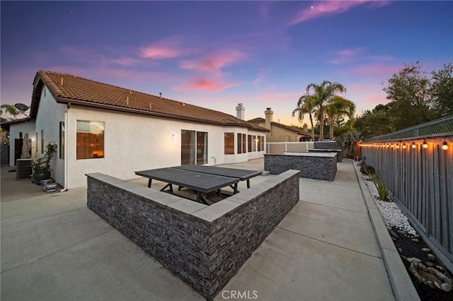 40065 Temple Ct, Murrieta, CA 92563 - back of house at dusk with a patio, a fenced backyard, a tile roof, and stucco siding