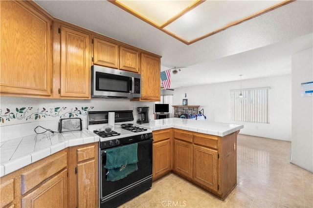 39513 Daylily Pl, Palmdale, CA 93551 - kitchen featuring range with gas stovetop, stainless steel microwave, a peninsula, and brown cabinetry
