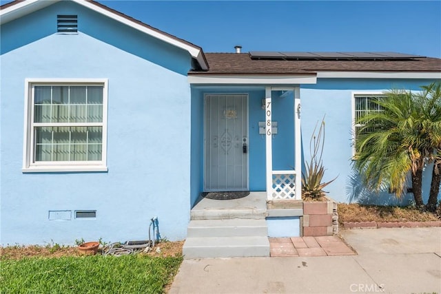 7086 Fairfax Dr, San Bernardino, CA 92404 - property entrance with stucco siding and roof mounted solar panels