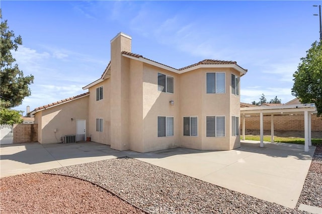 6879 Mission Grove Pkwy N, Riverside, CA 92506 - back of property featuring stucco siding, a patio area, a tiled roof, and a chimney