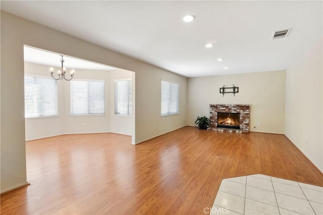 6879 Mission Grove Pkwy N, Riverside, CA 92506 - living room with a chandelier, light wood-style floors, a brick fireplace, and recessed lighting