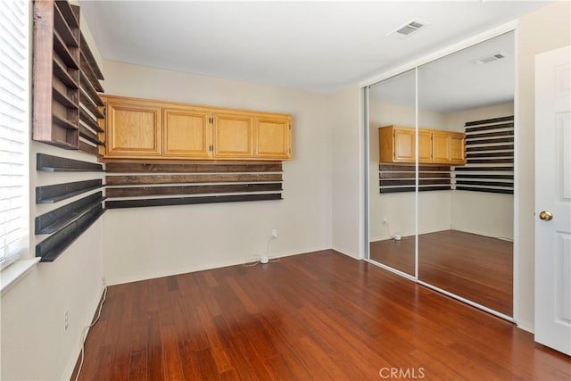 6879 Mission Grove Pkwy N, Riverside, CA 92506 - unfurnished bedroom with dark wood-style flooring and a closet