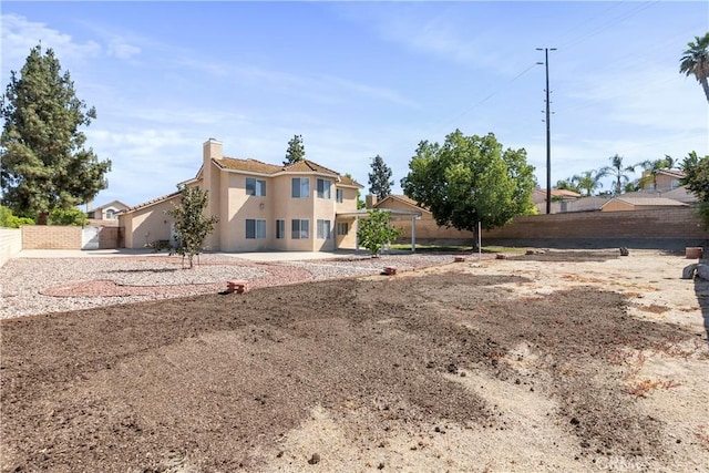 6879 Mission Grove Pkwy N, Riverside, CA 92506 - rear view of property with stucco siding and a chimney