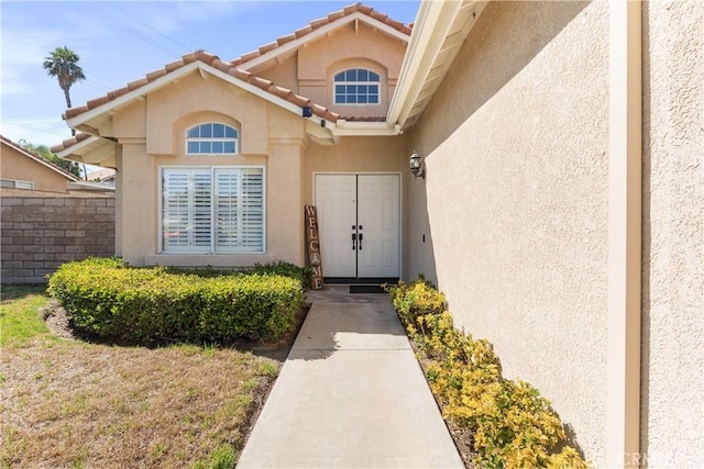 6879 Mission Grove Pkwy N, Riverside, CA 92506 - doorway to property with stucco siding and a tiled roof