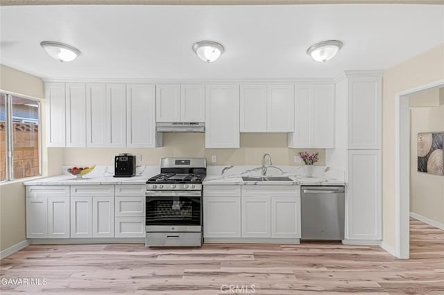 37858 10th St E, Palmdale, CA 93550 - kitchen with appliances with stainless steel finishes, under cabinet range hood, white cabinets, light wood-type flooring, and light stone counters