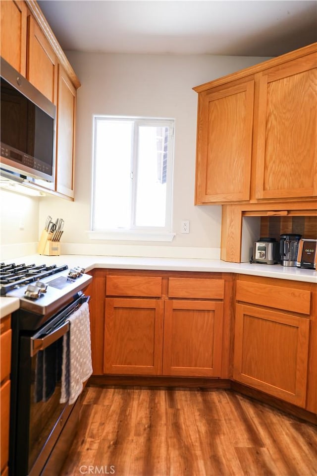 1639 La Selva Ave, Grover Beach, CA 93433 - kitchen featuring stainless steel appliances, dark wood finished floors, light countertops, and brown cabinetry