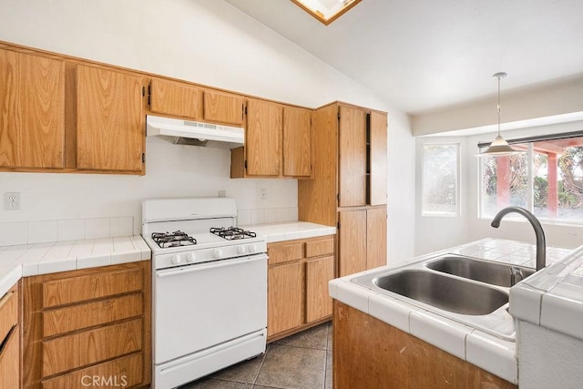 16205 Seville Ave, Fontana, CA 92335 - kitchen featuring white gas range, under cabinet range hood, vaulted ceiling, pendant lighting, and tile patterned flooring