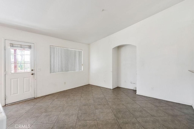16205 Seville Ave, Fontana, CA 92335 - spare room with arched walkways and tile patterned flooring