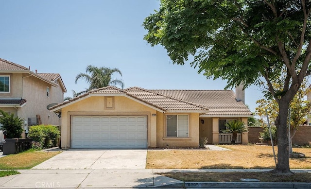 16205 Seville Ave, Fontana, CA 92335 - view of front of home featuring a tile roof, stucco siding, a garage, and driveway