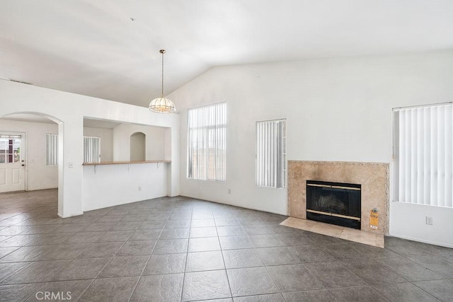 16205 Seville Ave, Fontana, CA 92335 - unfurnished living room featuring a high end fireplace, lofted ceiling, tile patterned floors, and arched walkways
