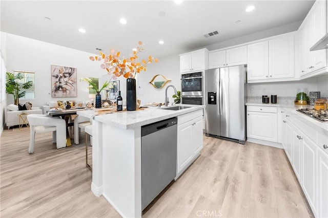 16471 Globetrotter St, Chino, CA 91708 - kitchen featuring appliances with stainless steel finishes, a center island with sink, light wood-style floors, white cabinetry, and recessed lighting