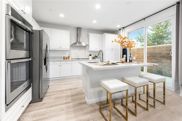 16471 Globetrotter St, Chino, CA 91708 - kitchen with wall chimney range hood, appliances with stainless steel finishes, light countertops, white cabinets, and recessed lighting