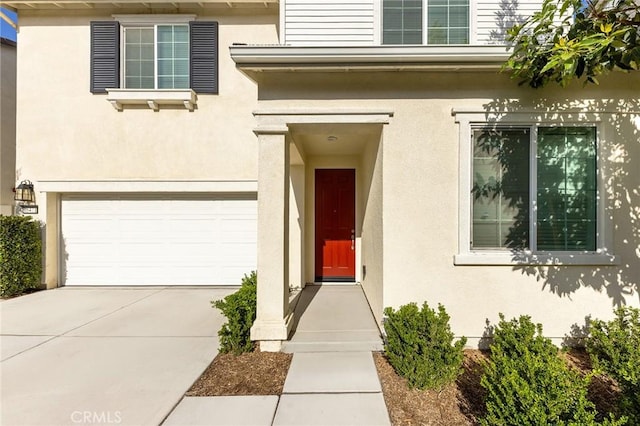 16471 Globetrotter St, Chino, CA 91708 - property entrance featuring a garage, stucco siding, and driveway