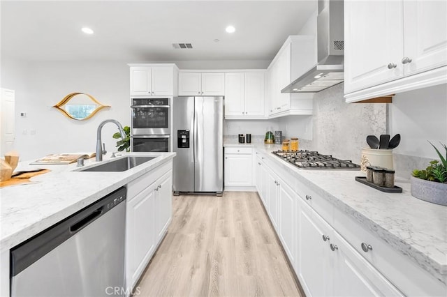16471 Globetrotter St, Chino, CA 91708 - kitchen with stainless steel appliances, wall chimney exhaust hood, white cabinetry, light wood-style floors, and recessed lighting