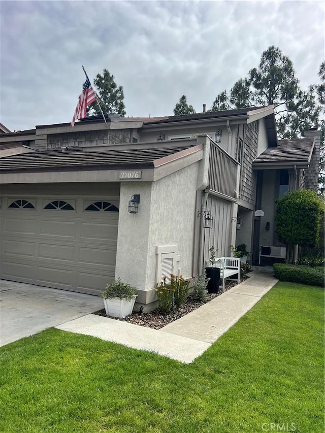 27076 Mill Pond Rd W Unit 9, Dana Point, CA 92624 - view of side of home featuring a yard, concrete driveway, and stucco siding