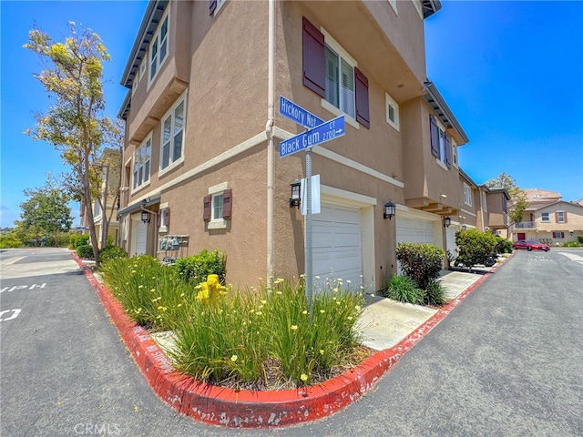 1652 Hickory Nut Pl, Chula Vista, CA 91915 - view of side of property featuring stucco siding, a garage, and a residential view
