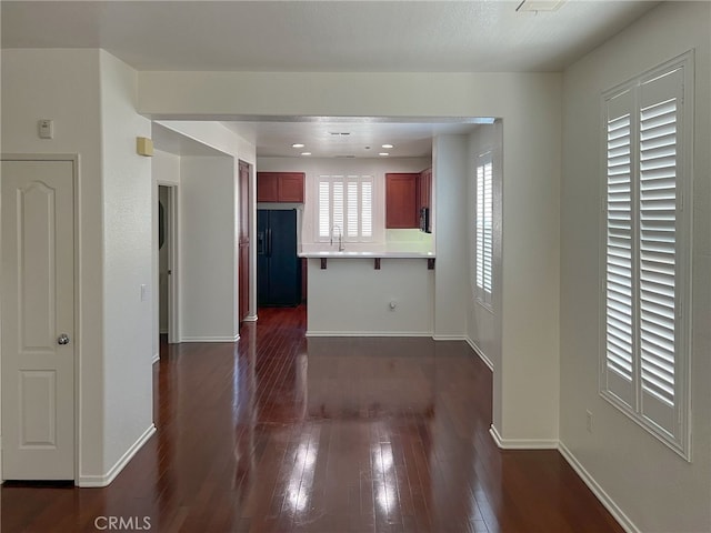 1652 Hickory Nut Pl, Chula Vista, CA 91915 - kitchen with a peninsula, black fridge, dark wood-style flooring, a breakfast bar, and light countertops