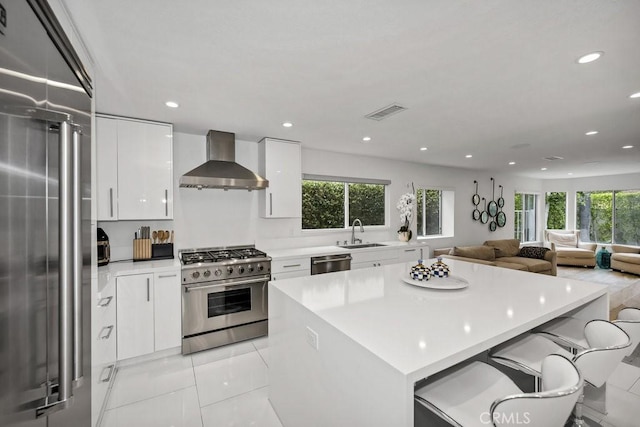 24523 Via Esquina, Calabasas, CA 91302 - kitchen with high end appliances, wall chimney range hood, healthy amount of natural light, a kitchen island, and recessed lighting