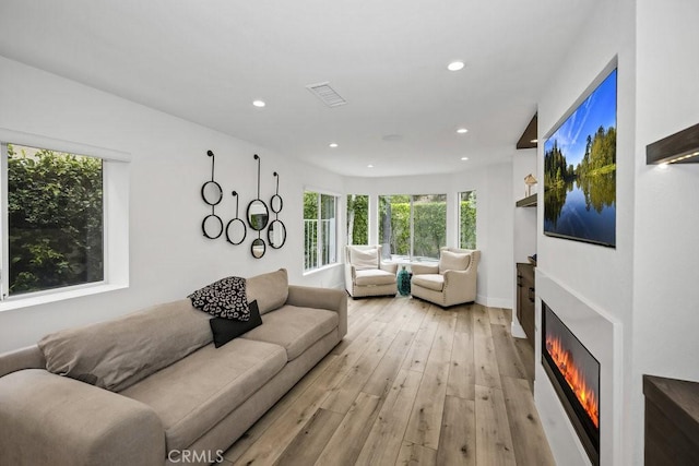 24523 Via Esquina, Calabasas, CA 91302 - living area featuring a lit fireplace, light wood-style floors, and recessed lighting