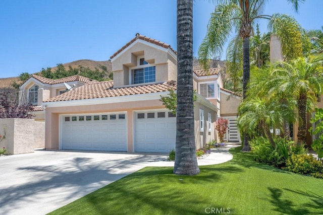 24523 Via Esquina, Calabasas, CA 91302 - mediterranean / spanish-style house featuring driveway, stucco siding, a tile roof, and a front lawn